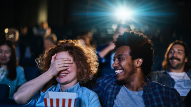 Audience enjoying a film together in a cinema, laughing and sharing the big screen experience