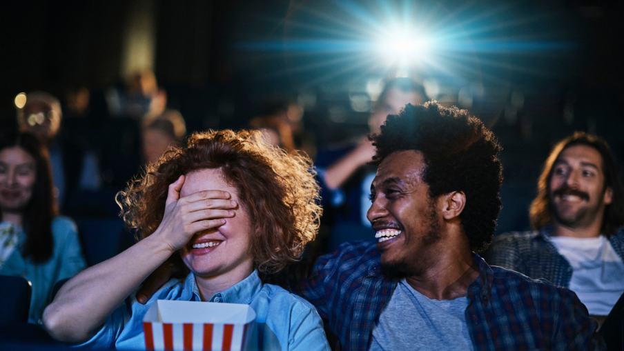 Audience enjoying a film together in a cinema, laughing and sharing the big screen experience