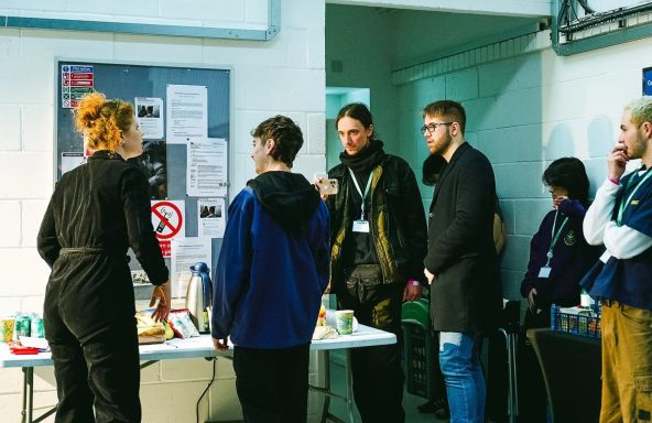 A busy film set with multiple cast and crew members preparing for a take.