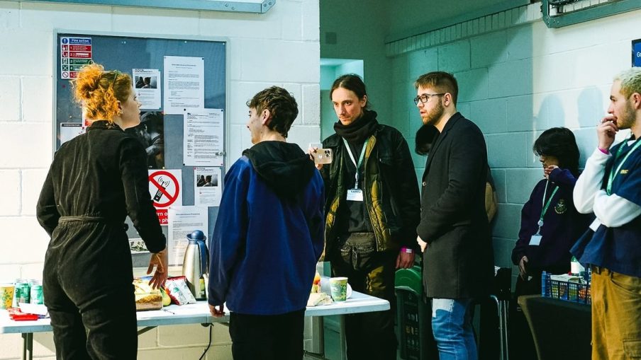 A busy film set with multiple cast and crew members preparing for a take.