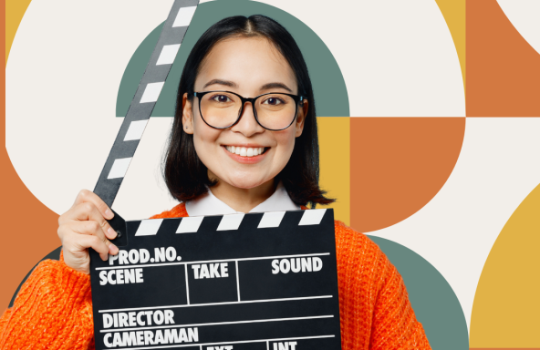 An Asian woman is smiling at the camera and holding a clapper board. Behind her is a pattern of the Reel Impact branding colours.