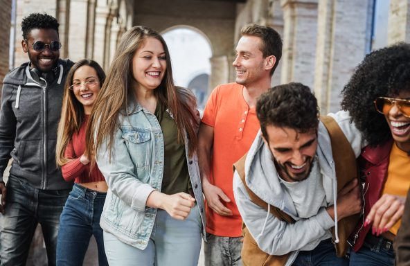 A group of six happy people walking together enjoying each others company with smiles on their faces