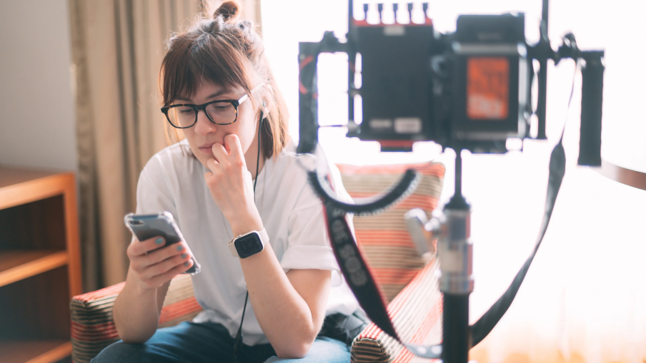 A behind-the-scenes industry worker is sat using their phone whilst on set